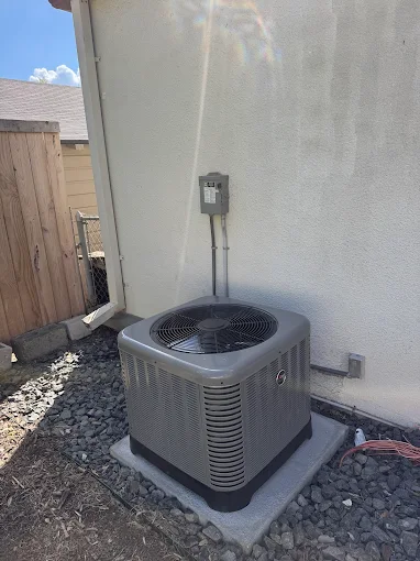An outdoor AC condenser unit beside a San Antonio, TX home during a hot Texas afternoon
